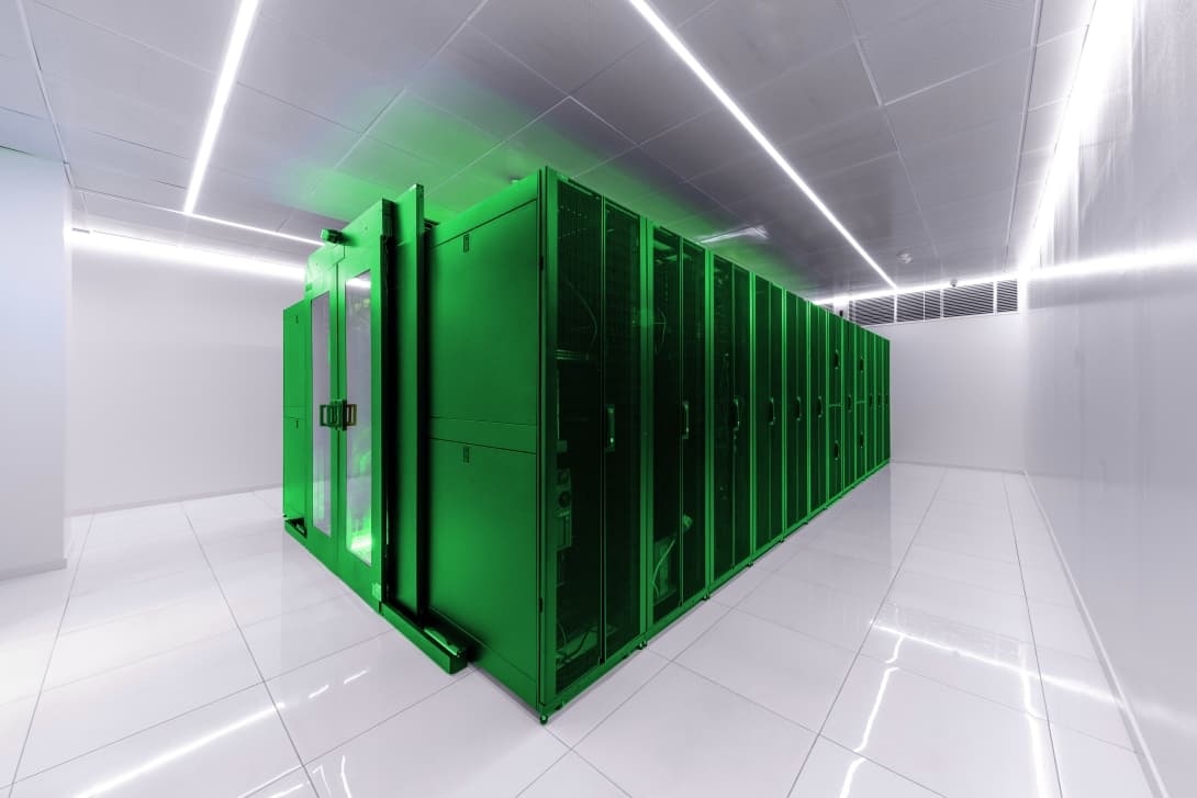 Row of Schneider Electric server cabinets lit green in the WaveCom data center